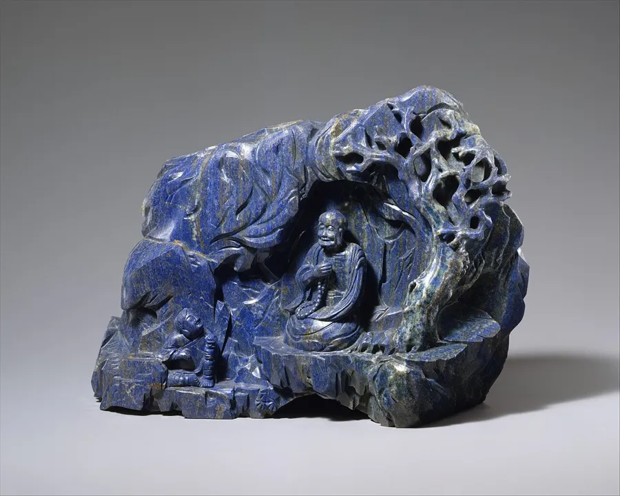 A luohan in a lapis grotto: A lapis lazuli boulder carved as a mountain grotto with a seated luohan, a Buddhist holy man.