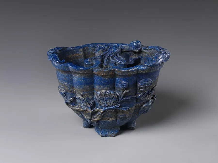 A Qing lapis tripod with a dragon: A small tripod vessel carved from lapis lazuli with a dragon, in the shape of an ancient bronze ding, made in Qing dynasty China.