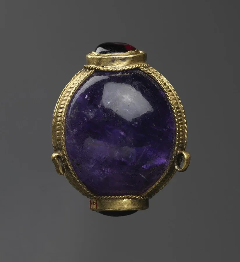 An amethyst ball pendant: A pendant set with a polished ball of amethyst in a gold mount.