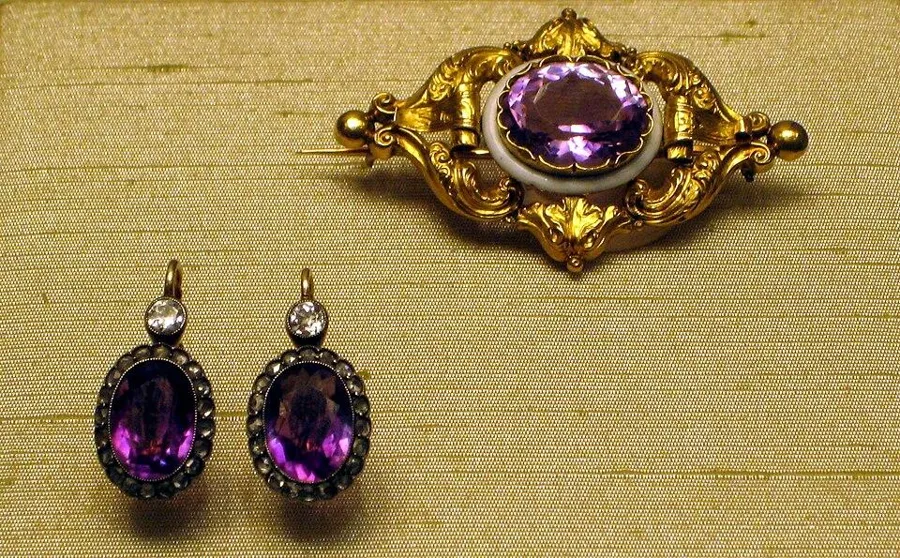 A Russian amethyst brooch and earrings: A gold and amethyst brooch by A. Holmström, St Petersburg, 1857 to 1864, with amethyst and diamond earrings made between 1908 and 1917.