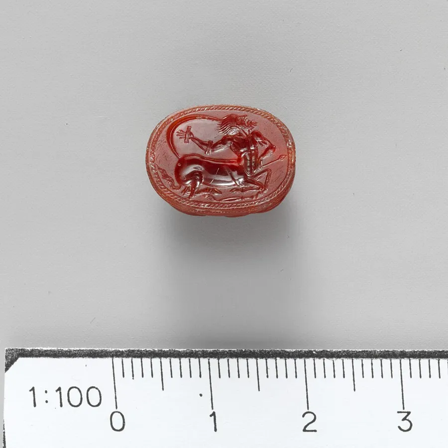 An Etruscan carnelian scarab: A carnelian scarab, 2.7 cm high, engraved on its flat underside. Etruscan, Classical, About 450 BC.