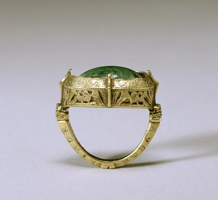 A bishop’s ring with a "toadstone": An English gold bishop’s ring with openwork eagles, animal heads and flowers, set with a large green malachite dome.