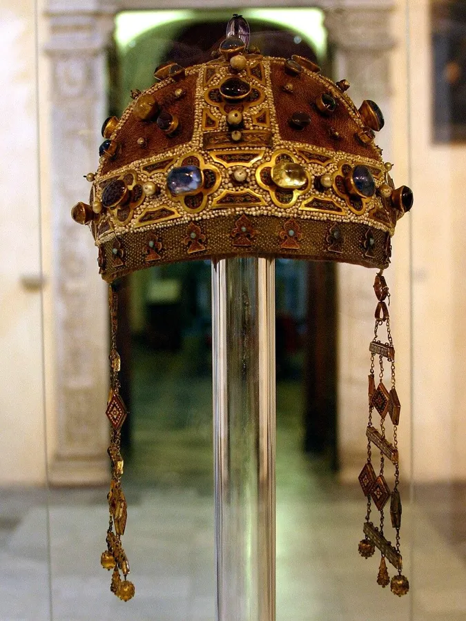 The crown of Constance of Aragon: A gold cap crown set with gems and pearls, with hanging strings of jewels, early 13th century.
