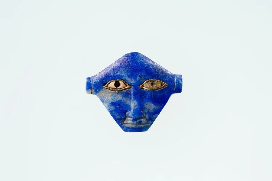 The face of Hathor: A face of the cow-eared goddess Hathor in lapis lazuli with gold and alabaster, only 1.2 cm tall, about 1100 to 664 BC.