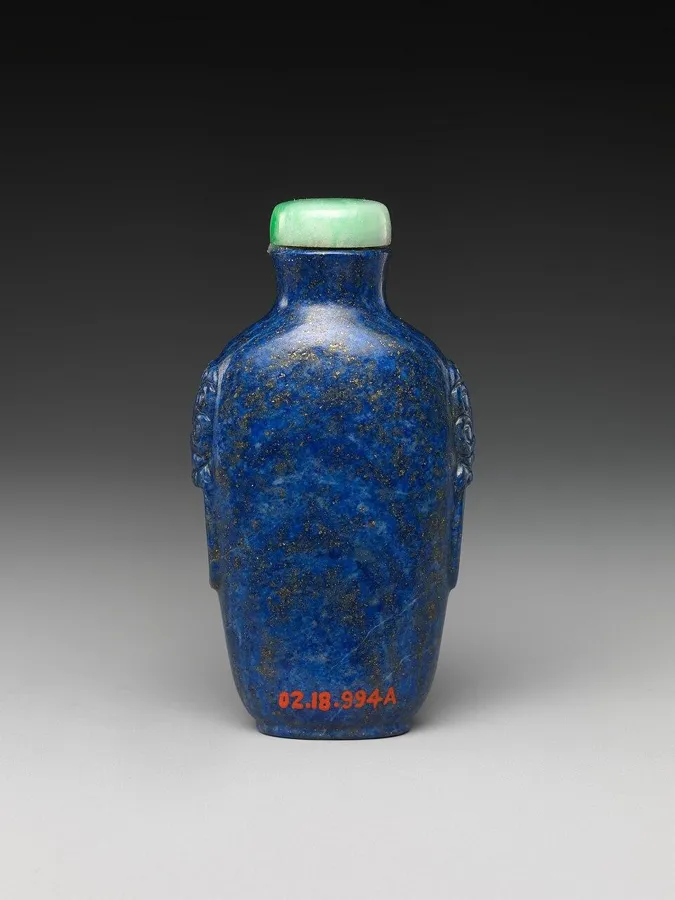 A Chinese lapis snuff bottle: A carved snuff bottle of lapis lazuli with a jadeite stopper, China, late 18th to early 19th century.