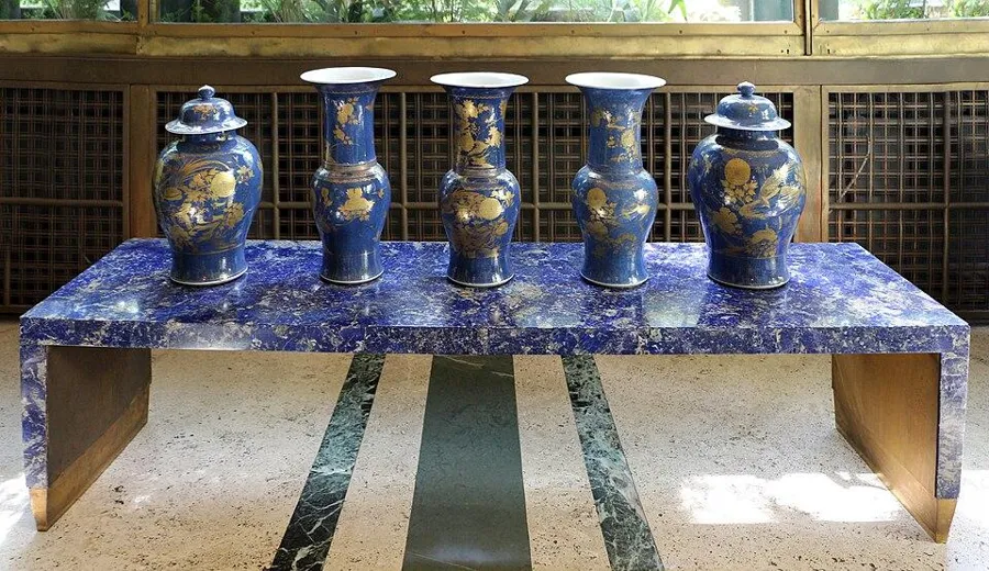 A table veneered in lapis: A small table covered in thin slices of lapis lazuli, with Chinese famille rose vases.