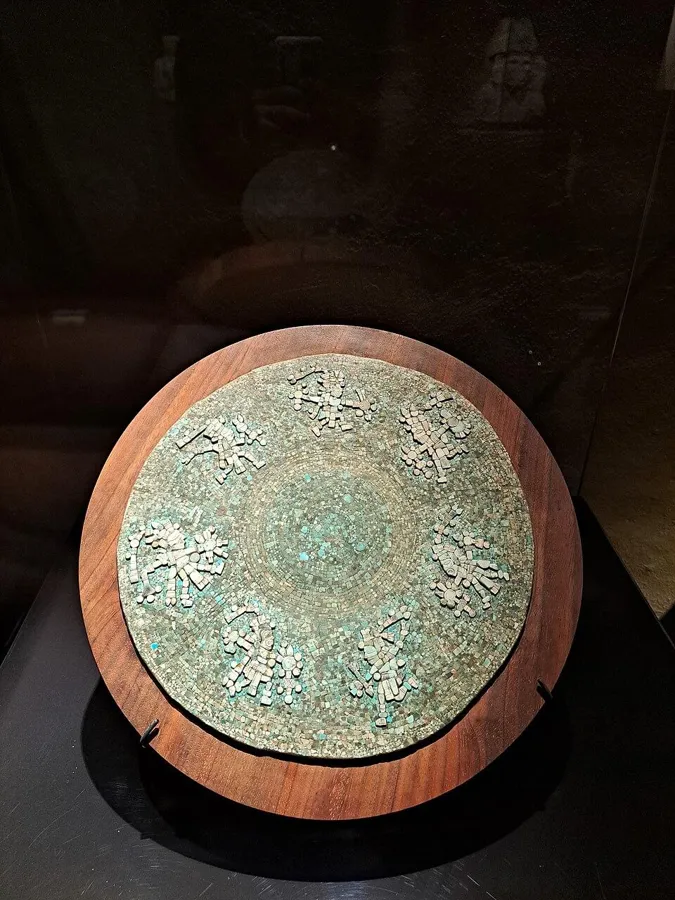 An Aztec turquoise mosaic disc: A round disc covered in small pieces of turquoise mosaic, Mexica (Aztec).