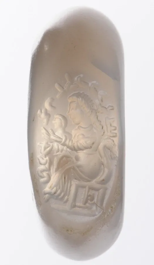 A Sasanian chalcedony seal: A stamp seal of milky chalcedony carved with a seated woman and a child, Persia, Sasanian period (224 to 651).
