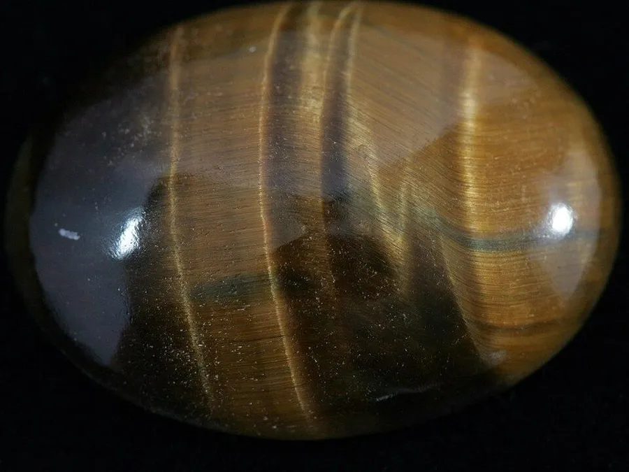 A tiger’s eye cabochon: A polished dome of tiger’s eye with the bright band that moves as you tilt it.