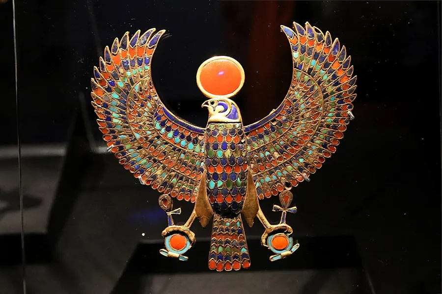 Tutankhamun’s falcon pectoral: A gold pectoral of the falcon god Horus with wings spread and a sun disc on his head, holding shen rings in his talons, inlaid with lapis lazuli, carnelian, turquoise and blue glass.
