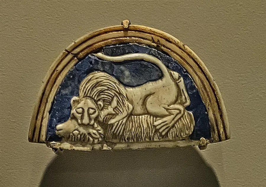 A lion and a ram in lapis and shell: A cosmetic box lid inlaid with lapis lazuli and shell, showing a lion bringing down a ram, royal cemetery of Ur, about 2500 BC.