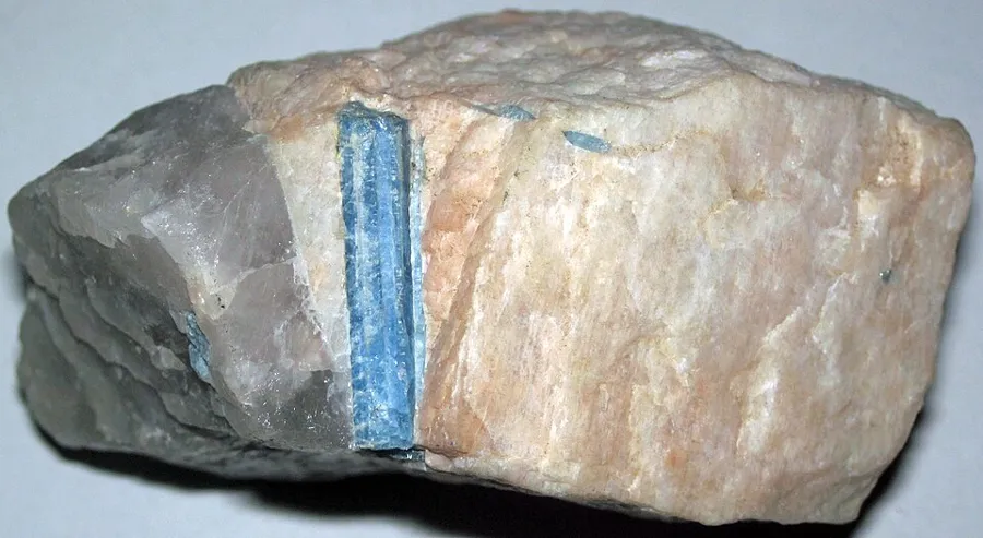 An aquamarine crystal still in its granite pegmatite, with quartz and feldspar.