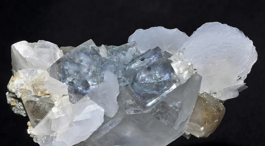 Pale blue fluorite cubes growing with calcite and scheelite.