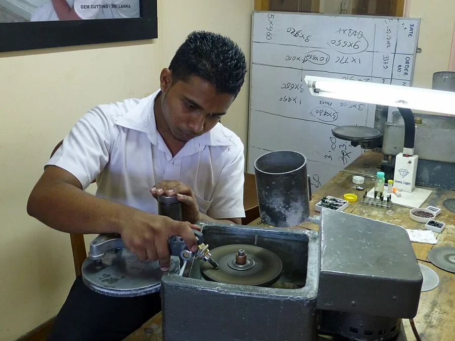 Cutting: a gem cutter at work in Sri Lanka, grinding facets on a spinning lap.