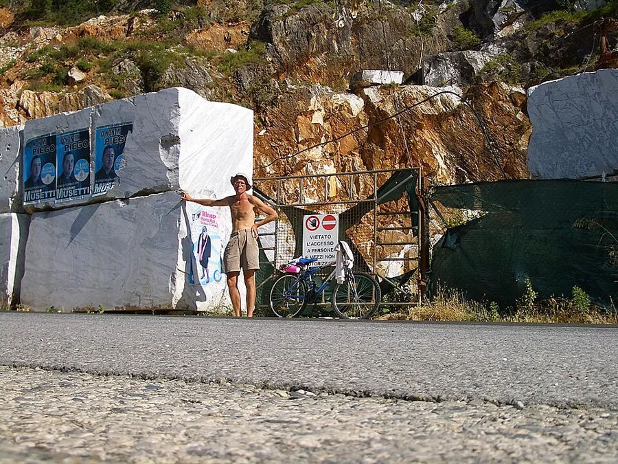 Blocks of marble cut from the mountain at Carrara, with a visitor for scale. A statue starts as a block like these.
