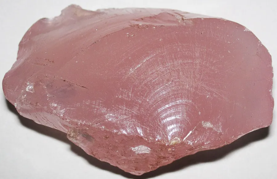 A broken face of rose quartz showing conchoidal, shell-like fracture, the way all quartz breaks.